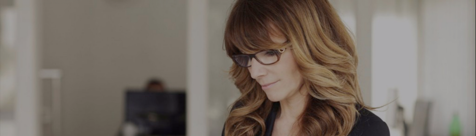 Woman reading on laptop and smiling