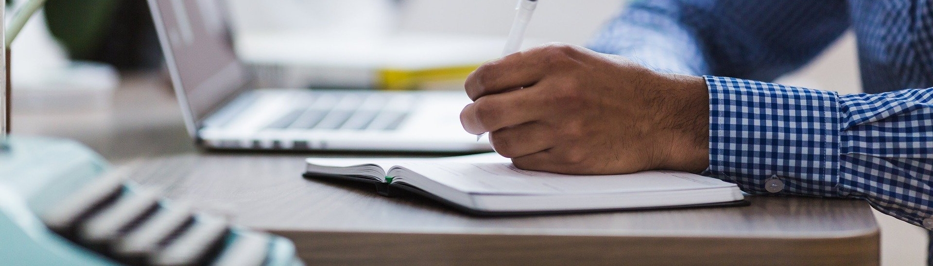 Close up of a man writing in a note pad