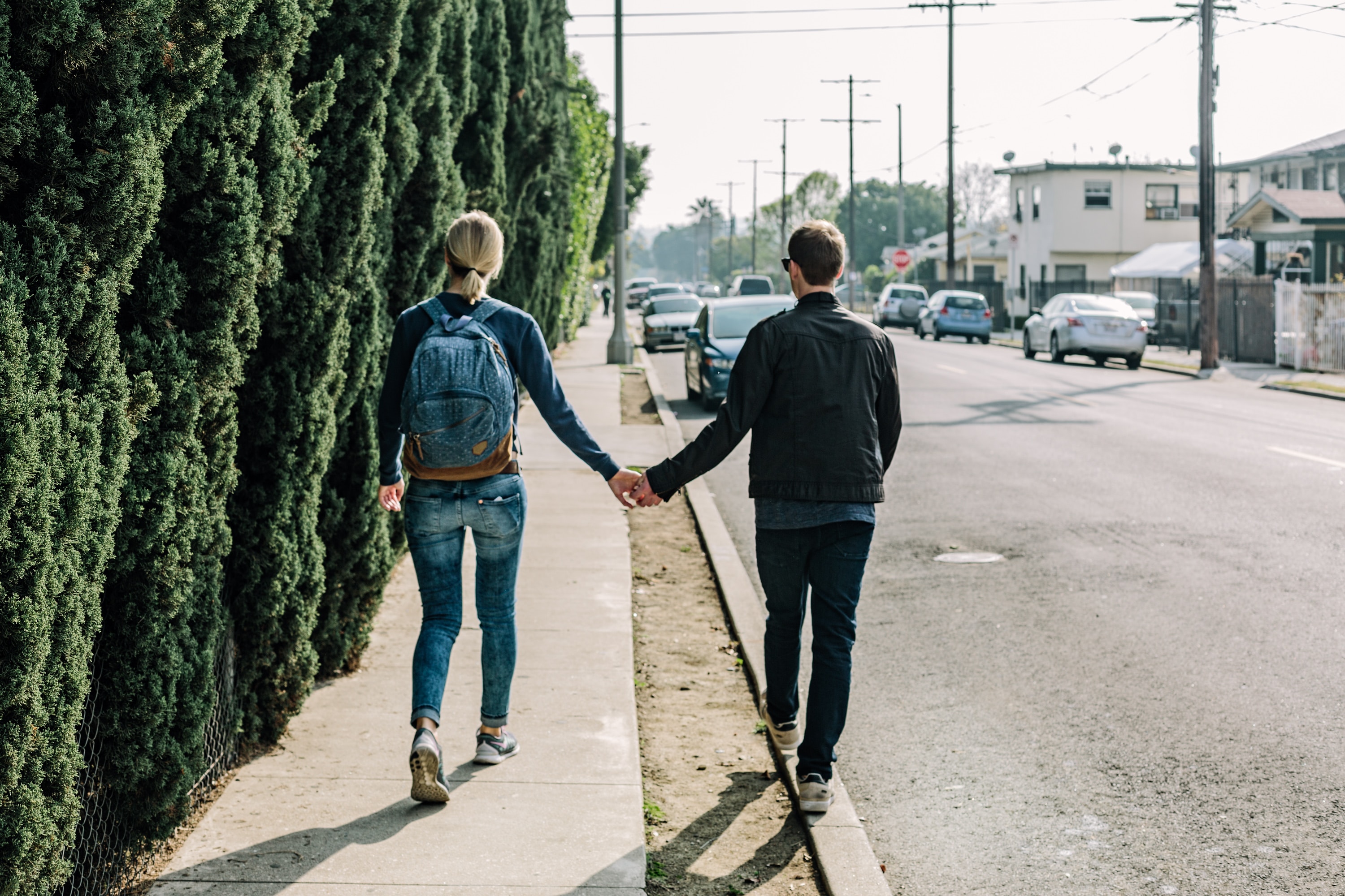 A young couple walk holding hands