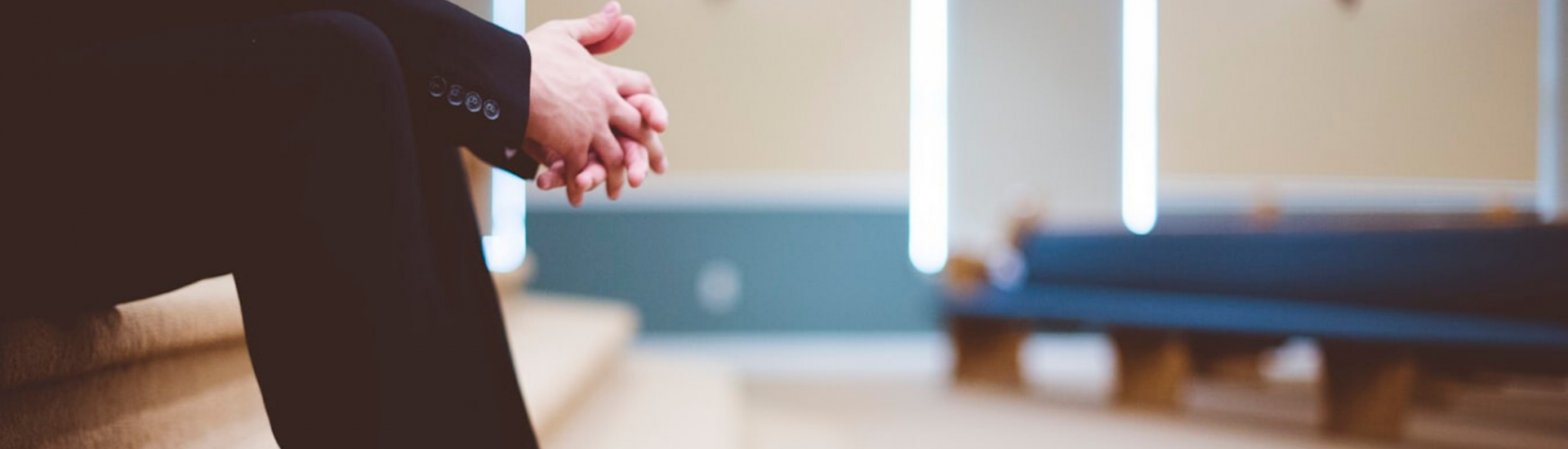 Man waits with hands clasped