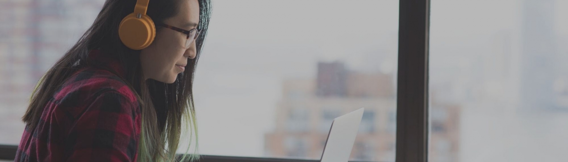 Young woman smiles on video chat with headphones